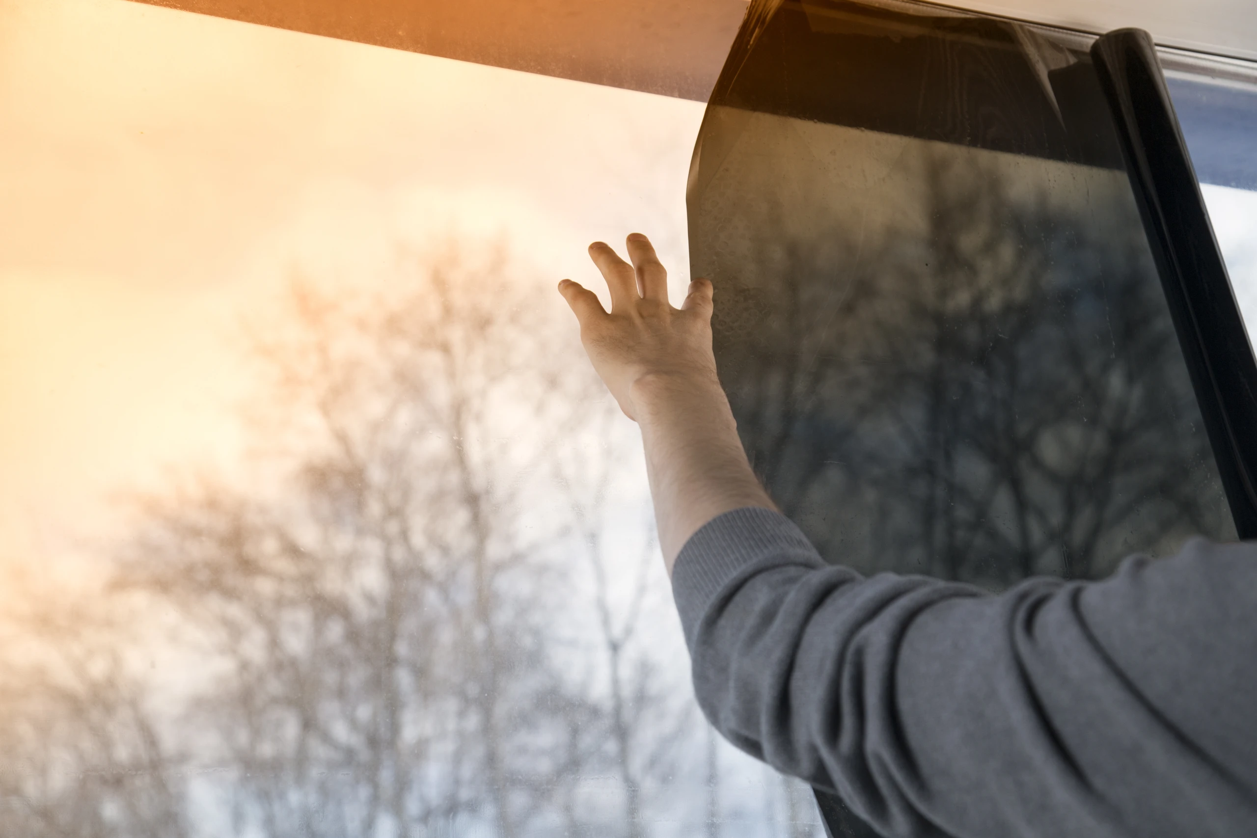 Pose d’un film solaire anti-UV sur un vitrage exposé au soleil